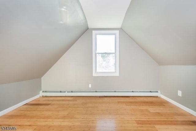 bonus room with a baseboard radiator, baseboards, lofted ceiling, and wood finished floors