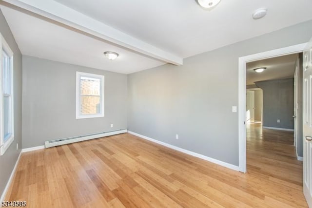 spare room featuring a baseboard heating unit, beam ceiling, baseboards, and light wood finished floors