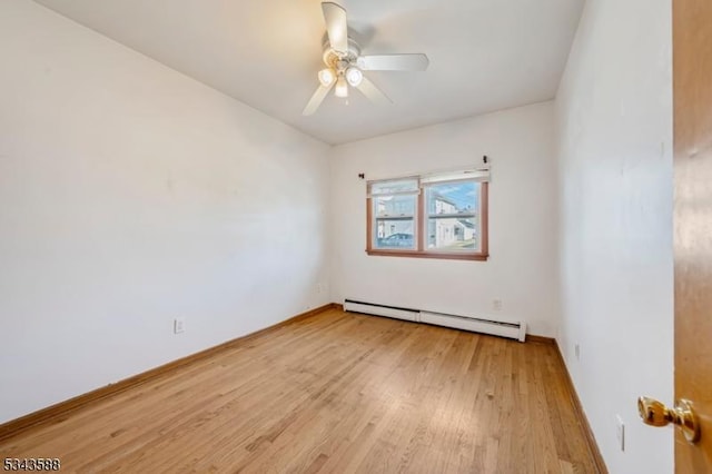 empty room featuring wood finished floors, a ceiling fan, baseboards, and a baseboard radiator