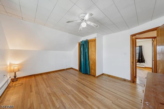 bonus room featuring lofted ceiling, baseboard heating, baseboards, and light wood finished floors