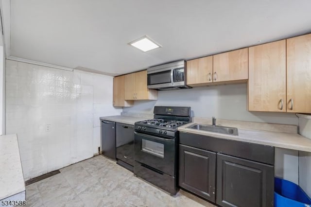 kitchen with black gas range oven, stainless steel microwave, dishwasher, light countertops, and a sink