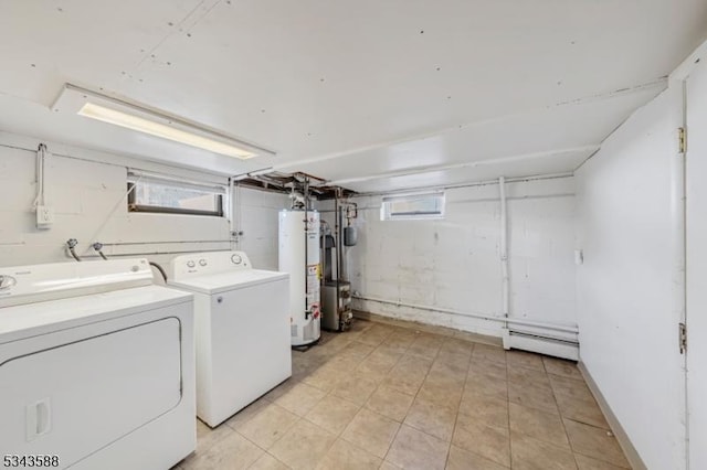 washroom featuring laundry area, washing machine and dryer, water heater, and a baseboard radiator