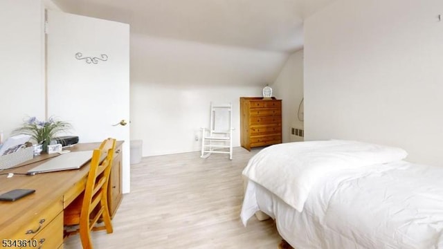 bedroom with vaulted ceiling and light wood finished floors