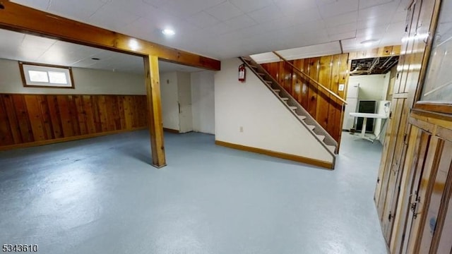 basement with stairway and wood walls