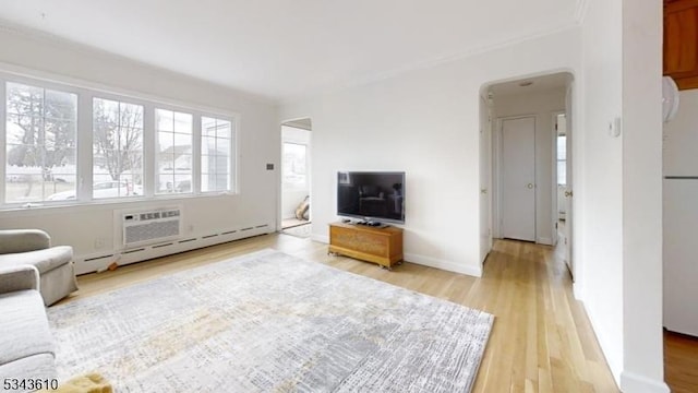 unfurnished living room with arched walkways, light wood-type flooring, and baseboards