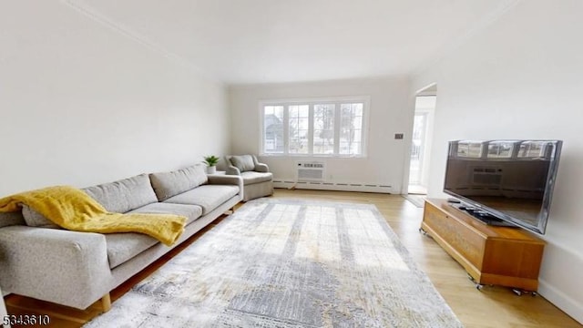 living area featuring a wall mounted air conditioner, light wood-type flooring, and a baseboard heating unit