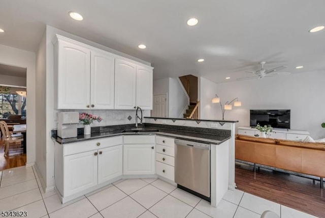 kitchen with a ceiling fan, a sink, white cabinetry, a peninsula, and dishwasher