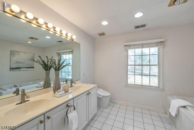 bathroom with tile patterned flooring, visible vents, a bath, and a sink