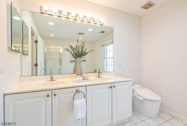 bathroom with a sink, toilet, a stall shower, and tile patterned flooring