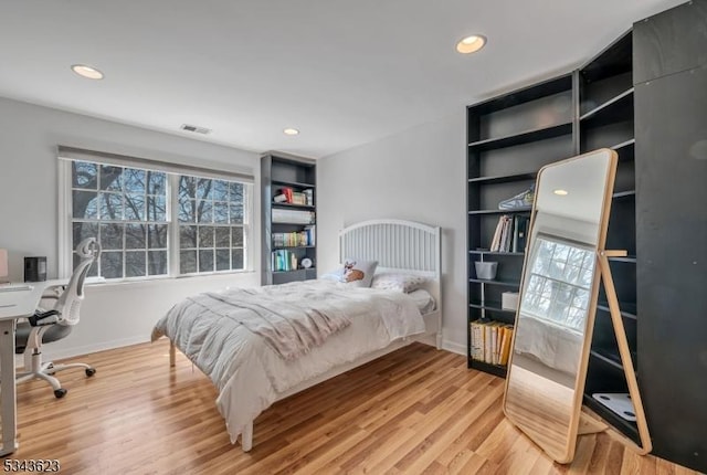 bedroom with recessed lighting, visible vents, baseboards, and wood finished floors