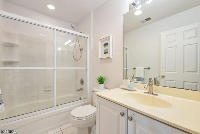 full bathroom with visible vents, toilet, shower / bath combination with glass door, tile patterned floors, and vanity