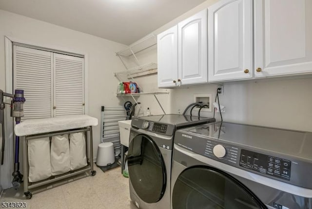 washroom with cabinet space and washing machine and clothes dryer