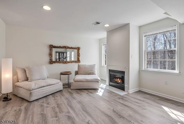 living area featuring baseboards, plenty of natural light, and wood finished floors