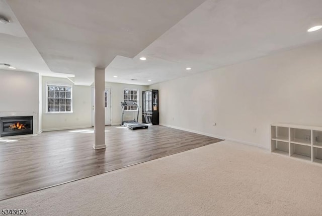 basement featuring recessed lighting, baseboards, carpet floors, and wood finished floors