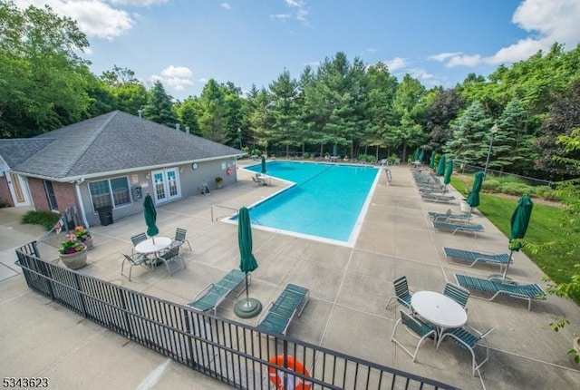 pool with french doors, a patio, and fence