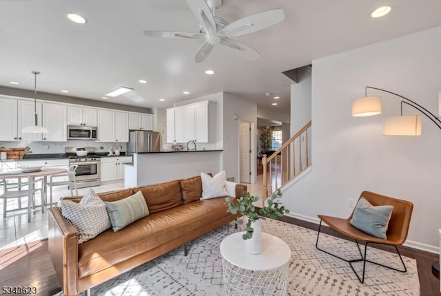 living area featuring stairs, light wood-style flooring, recessed lighting, and ceiling fan