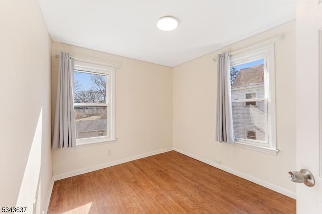 empty room featuring wood finished floors and baseboards