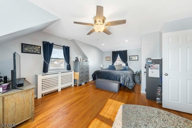 bedroom with lofted ceiling and light wood-style floors