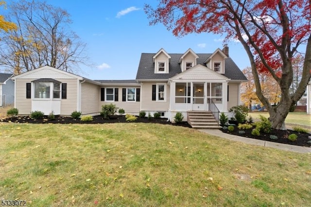 view of front facade featuring a chimney, a front lawn, and a sunroom