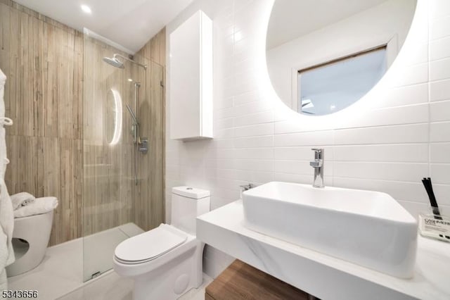 full bath featuring tile walls, toilet, a stall shower, and a sink