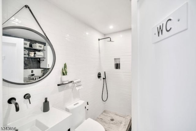 bathroom with a stall shower, toilet, and a sink