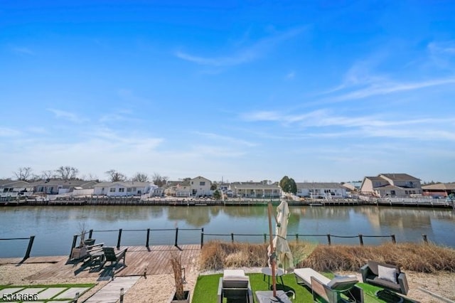 view of water feature featuring a residential view, a dock, and fence