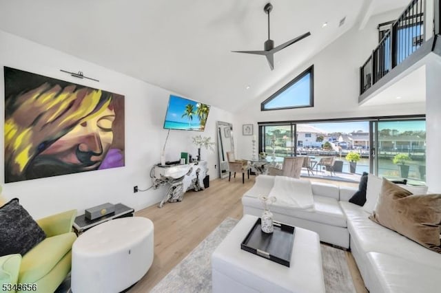 living area with high vaulted ceiling, ceiling fan, and wood finished floors