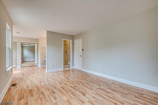 interior space featuring light wood-type flooring, visible vents, and baseboards