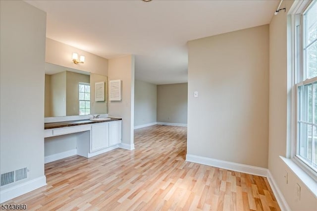 bathroom with a wealth of natural light, baseboards, and wood finished floors