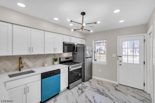 kitchen with backsplash, white cabinets, stainless steel appliances, marble finish floor, and a sink