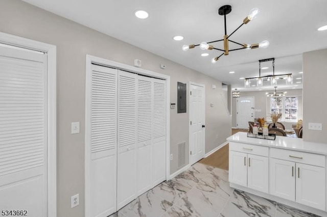 kitchen featuring a chandelier, pendant lighting, recessed lighting, marble finish floor, and white cabinetry