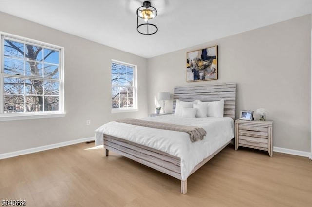 bedroom featuring baseboards and wood finished floors