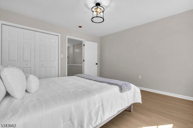 bedroom featuring a closet, baseboards, and wood finished floors