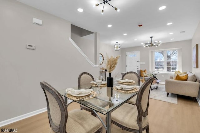 dining area with recessed lighting, baseboards, a notable chandelier, and light wood-style flooring