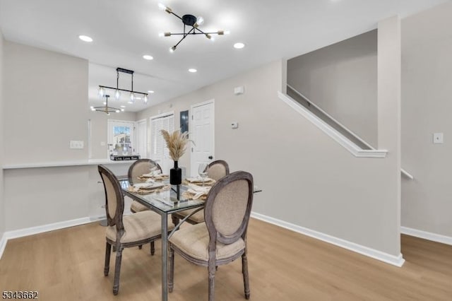 dining room with recessed lighting, baseboards, a notable chandelier, and wood finished floors