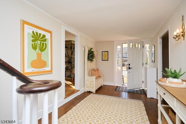 entrance foyer featuring baseboards, dark wood-style floors, and crown molding