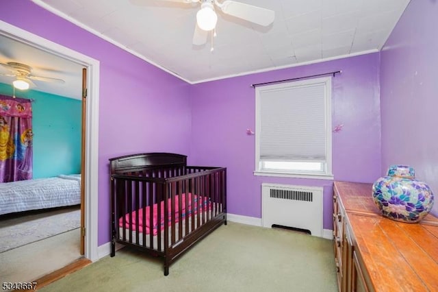 bedroom with carpet flooring, radiator heating unit, and ceiling fan