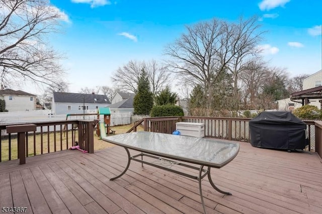 wooden deck with grilling area, outdoor dining area, and fence