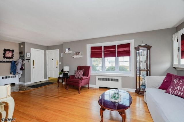 living area featuring radiator, baseboards, and light wood-style floors