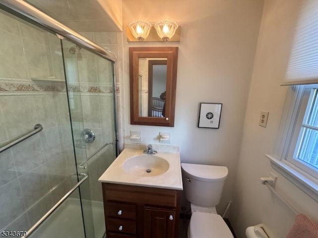 full bath featuring toilet, a stall shower, and vanity