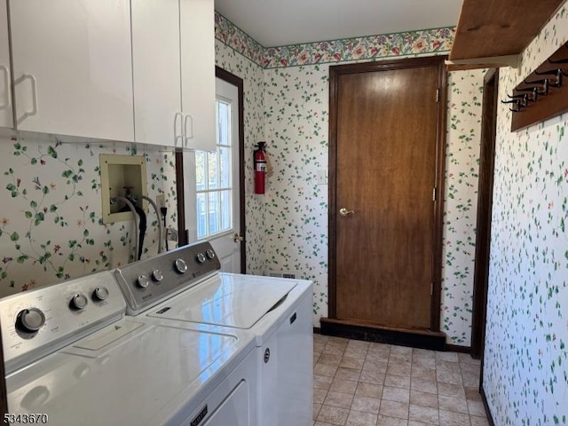 clothes washing area featuring cabinet space, wallpapered walls, and separate washer and dryer