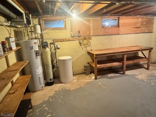 unfinished basement featuring a workshop area and water heater