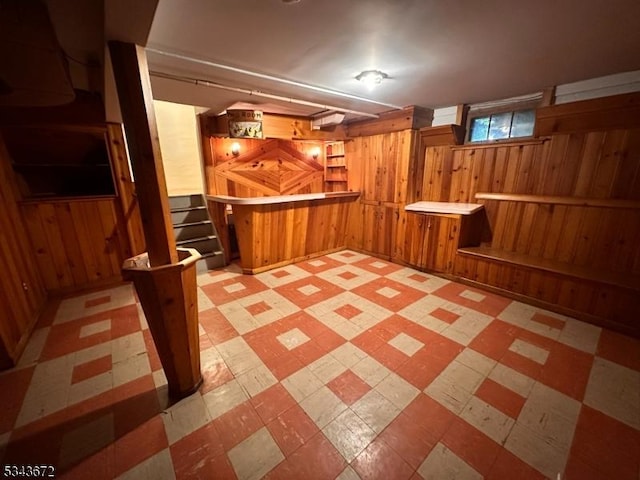 131 Beverly Rd, Bloomfield Twp, NJ 07003 - basement featuring wooden walls, tile patterned floors, a dry bar, and stairs