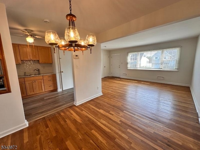 131 Beverly Rd, Bloomfield Twp, NJ 07003 - unfurnished dining area featuring a chandelier, dark wood-style floors, a sink, and baseboards