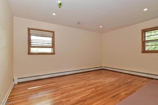 unfurnished room with light wood finished floors, visible vents, recessed lighting, and a baseboard radiator