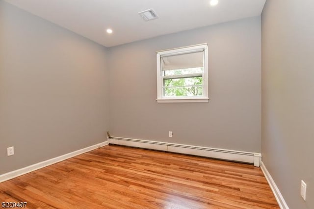 empty room with recessed lighting, light wood-style floors, baseboards, and baseboard heating