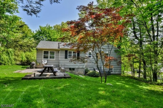 back of house featuring a patio area and a lawn