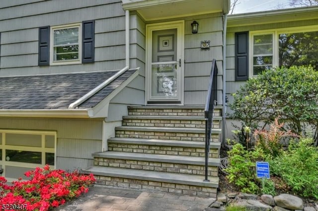 entrance to property featuring a shingled roof