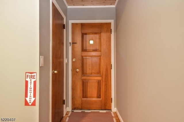 corridor with crown molding and baseboards