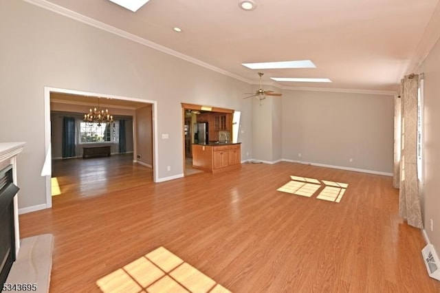 unfurnished living room with a fireplace with raised hearth, baseboards, ornamental molding, vaulted ceiling with skylight, and light wood-style floors